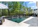 Luxury pool featuring built-in water feature with lounge chairs and a striped umbrella for shade at 14013 Pinoli Pine Cir, Huntersville, NC 28078