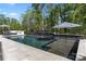 Stunning in-ground pool with water features, surrounded by a sleek patio and mature trees at 14013 Pinoli Pine Cir, Huntersville, NC 28078