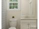 Well-lit bathroom with a white toilet, vanity with storage, and a window for natural light at 1512 Croydon St, Indian Land, SC 29707
