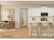 Open kitchen with white cabinets, an island with bar stools, and a cozy dining area at 1512 Croydon St, Indian Land, SC 29707