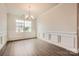 Formal dining room featuring hardwood floors, modern wainscoting, a modern chandelier, and a large window at 1541 Croydon St, Indian Land, SC 29707