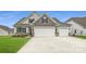 Charming two-story home featuring a three-car garage, well-maintained lawn, and stone and shingle accents at 1541 Croydon St, Indian Land, SC 29707