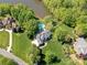 Aerial view showcasing a luxury home with a pool, manicured lawns, and mature trees near a lake at 1700 White Pond Ln, Waxhaw, NC 28173