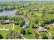 An aerial view of luxury homes by a lake, surrounded by lush greenery and manicured lawns at 1700 White Pond Ln, Waxhaw, NC 28173