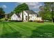Beautiful home with a well-manicured lawn, mature trees, and a serene lake view at 1700 White Pond Ln, Waxhaw, NC 28173