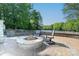 Outdoor living space featuring a stone fire pit with seating and views of the lake at 1700 White Pond Ln, Waxhaw, NC 28173