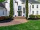 Elegant front entrance with double doors, tall windows, manicured trees and brick walkway at 1700 White Pond Ln, Waxhaw, NC 28173