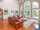 Bright living room with high ceilings, hardwood floors, leather sofas, and backyard views at 1700 White Pond Ln, Waxhaw, NC 28173