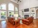 Inviting living room with a fireplace, hardwood floors, leather sofas, and bright natural light at 1700 White Pond Ln, Waxhaw, NC 28173
