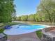 A backyard pool with lounge chairs, a brick patio, and a view of the lake at 1700 White Pond Ln, Waxhaw, NC 28173