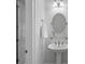 Half bath with pedestal sink, oval mirror, glass shelf, and neutral decor at 1717 Brawley School Rd, Mooresville, NC 28117
