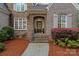 Charming stone-accented entrance with a welcoming front door, complemented by colorful landscaping and elegant details at 1717 Brawley School Rd, Mooresville, NC 28117