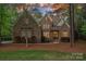 Charming two-story home with stone and brick facade, complemented by manicured landscaping and mature trees at 1717 Brawley School Rd, Mooresville, NC 28117