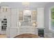 Elegant dining area with display cabinets, a wine cooler, and a modern chandelier, perfect for entertaining at 1717 Brawley School Rd, Mooresville, NC 28117