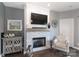 Living room with stone fireplace, wooden mantel, decorative accessories, and patterned armchair at 18832 Nautical Dr # 41, Cornelius, NC 28031