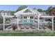 A community pool framed by a pergola, lounge chairs, and well-maintained fencing at 18832 Nautical Dr # 41, Cornelius, NC 28031