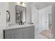 Bathroom features a gray vanity with marble countertop, a black framed mirror and modern lighting fixtures at 2027 Thurmond Pl, Charlotte, NC 28205