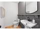 Modern half bathroom with pedestal sink, elegant mirror, and stylish fixtures at 2027 Thurmond Pl, Charlotte, NC 28205