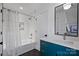 Bright bathroom with blue vanity, shower-tub combo and stylish black hardware at 2027 Thurmond Pl, Charlotte, NC 28205