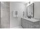Bathroom featuring a gray vanity with marble countertop, shower with gray tile and a black framed mirror at 2027 Thurmond Pl, Charlotte, NC 28205