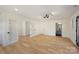 Spacious bedroom with a modern light fixture, glass doors, white walls, and luxury vinyl plank flooring at 2027 Thurmond Pl, Charlotte, NC 28205