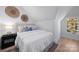 Cozy bedroom with sloped ceilings, queen bed, bedside table, and a window with natural light at 2027 Thurmond Pl, Charlotte, NC 28205