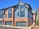 Exterior of two-story townhomes featuring a mix of blue siding and brick, highlighted by well-placed windows and gray garages at 2027 Thurmond Pl, Charlotte, NC 28205