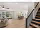 Open-concept living space showcasing hardwood floors, dining area, and staircase, illuminated by natural light at 2027 Thurmond Pl, Charlotte, NC 28205