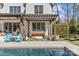 Inviting pool area with comfortable seating, pergola, and well-manicured landscaping for a relaxing backyard oasis at 2137 Foxcroft Woods Ln, Charlotte, NC 28211