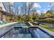 Stunning backyard oasis with a sparkling pool, inviting hot tub, and comfortable lounge chairs, surrounded by lush greenery at 2137 Foxcroft Woods Ln, Charlotte, NC 28211