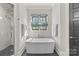 Bright bathroom featuring a soaking tub, modern fixtures, and a window for natural light; a spa-like retreat at 2137 Foxcroft Woods Ln, Charlotte, NC 28211