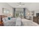 Comfortable bedroom featuring a ceiling fan, sitting area, and bright natural light from the large windows at 2137 Foxcroft Woods Ln, Charlotte, NC 28211