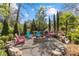 Inviting outdoor firepit area with Adirondack chairs nestled among lush landscaping and natural stone accents at 2137 Foxcroft Woods Ln, Charlotte, NC 28211