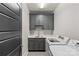 Well-organized laundry room with sleek cabinetry, stainless steel sink, and modern appliances at 2137 Foxcroft Woods Ln, Charlotte, NC 28211
