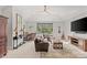 Spacious living room featuring a ceiling fan, television, leather seating, and backyard views at 2137 Foxcroft Woods Ln, Charlotte, NC 28211