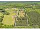 Aerial view of wooded parcel featuring a red brick home, outbuildings, and a clearly defined property line at 2251 Old Applewood Ln # 9, Iron Station, NC 28080