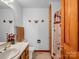 A clean bathroom with a single sink vanity, toilet, and shower behind a floral curtain at 2251 Old Applewood Ln # 9, Iron Station, NC 28080
