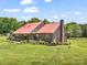 Brick home featuring a red metal roof, covered porch, and manicured landscaping at 2251 Old Applewood Ln # 9, Iron Station, NC 28080