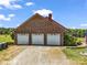 Three-car garage with white doors in a brick home; American flag in yard at 2251 Old Applewood Ln # 9, Iron Station, NC 28080