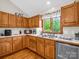 A sunlit kitchen featuring wood cabinets, a stainless steel dishwasher, and a window with nature views at 2251 Old Applewood Ln # 9, Iron Station, NC 28080