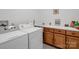 A bright laundry room with modern washer and dryer, cabinets, and counter with sink at 2251 Old Applewood Ln # 9, Iron Station, NC 28080