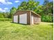 A metal outbuilding with two garage doors on a grassy lot surrounded by trees at 2251 Old Applewood Ln # 9, Iron Station, NC 28080