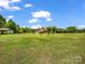 Scenic view of a home with a large grassy area and mature trees under a blue sky at 2251 Old Applewood Ln # 9, Iron Station, NC 28080