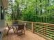 Wooden back deck surrounded by forest features an outdoor dining set at 2302 Jordi Way, Charlotte, NC 28213