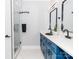 Bathroom with double sinks, modern fixtures, blue vanity and shower at 2302 Jordi Way, Charlotte, NC 28213