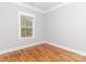 A well-lit bedroom featuring hardwood floors, a large window, and neutral-toned walls at 2302 Jordi Way, Charlotte, NC 28213