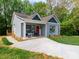 Charming home featuring a well-manicured lawn, inviting front porch, and gray wood siding at 2302 Jordi Way, Charlotte, NC 28213