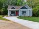 Charming home featuring a well-manicured lawn, inviting front porch, and a vibrant red front door at 2302 Jordi Way, Charlotte, NC 28213