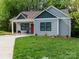 Charming home featuring a well-manicured lawn, inviting front porch, and gray wood siding at 2302 Jordi Way, Charlotte, NC 28213