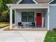 Inviting front porch featuring a seating area and a vibrant red front door at 2302 Jordi Way, Charlotte, NC 28213